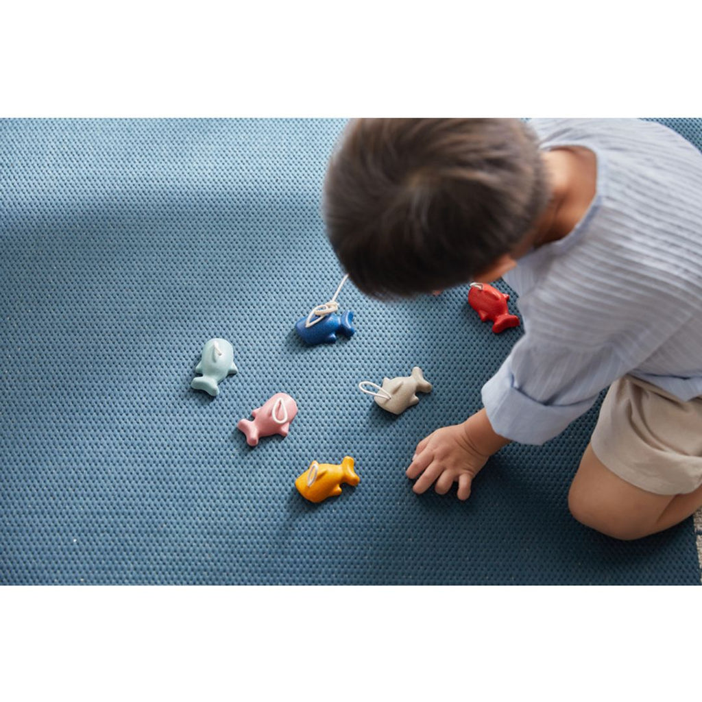 Kid playing PlanToys Fishing Game