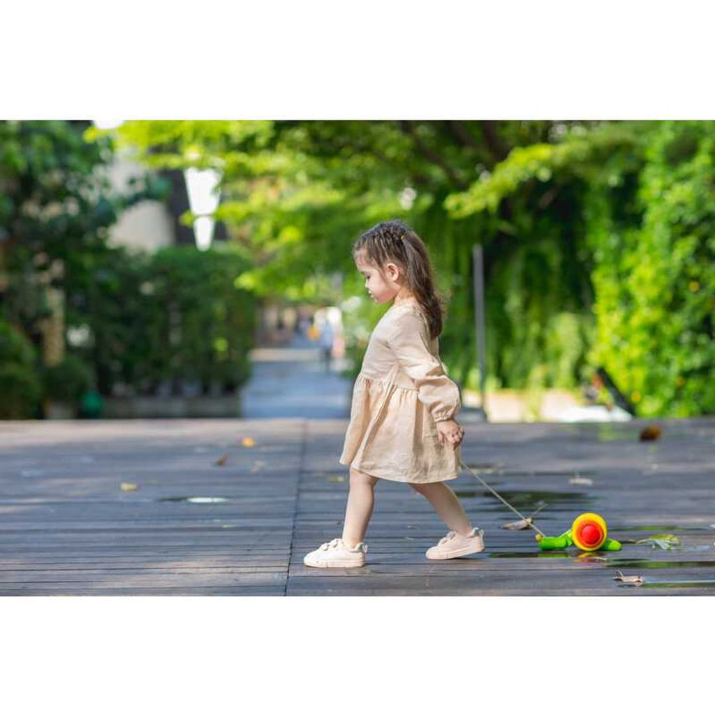 Kid playing PlanToys Pull Along Snail