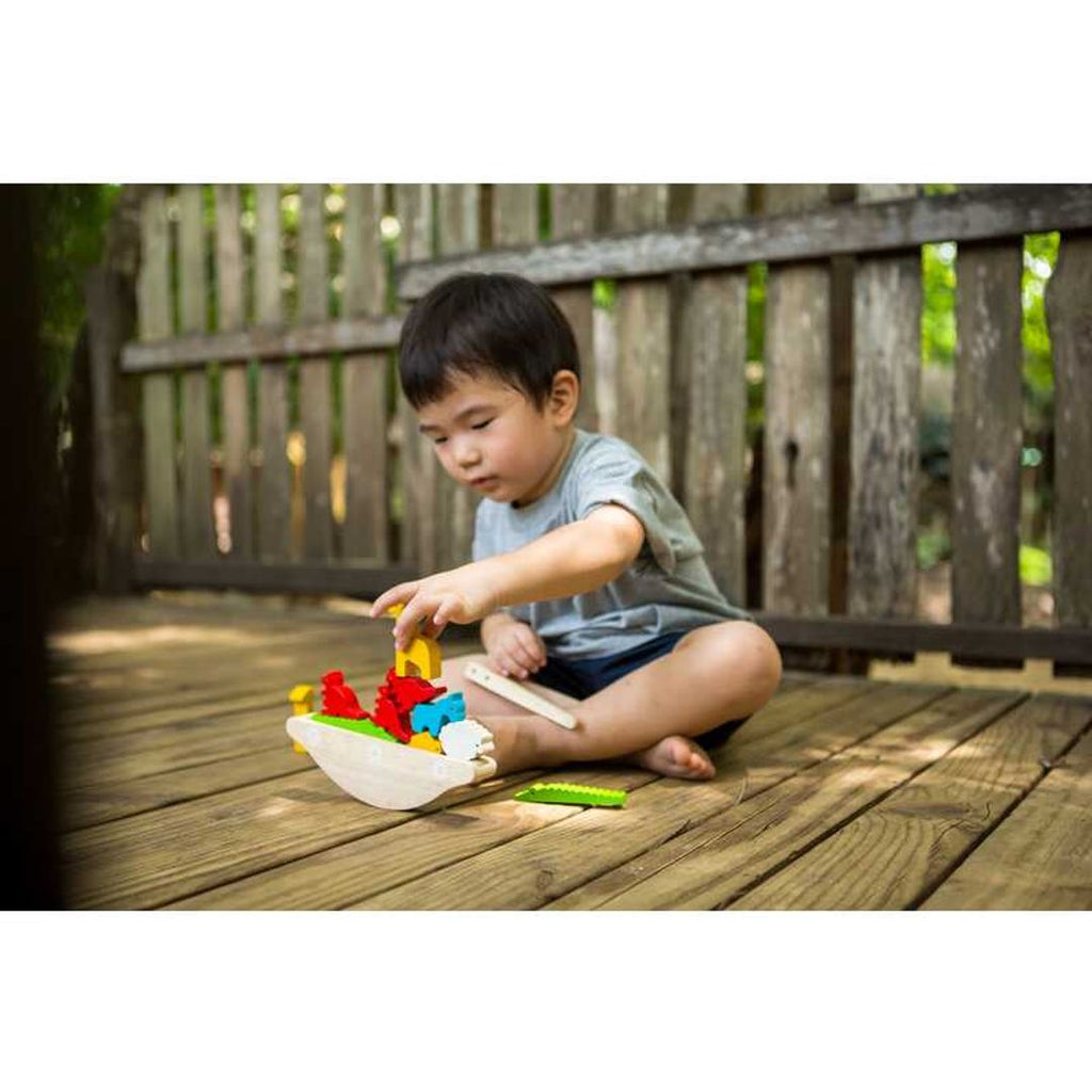 Kid playing PlanToys Balancing Boat