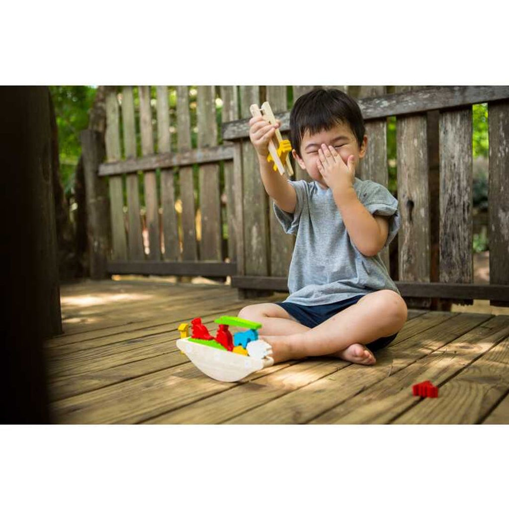 Kid playing PlanToys Balancing Boat