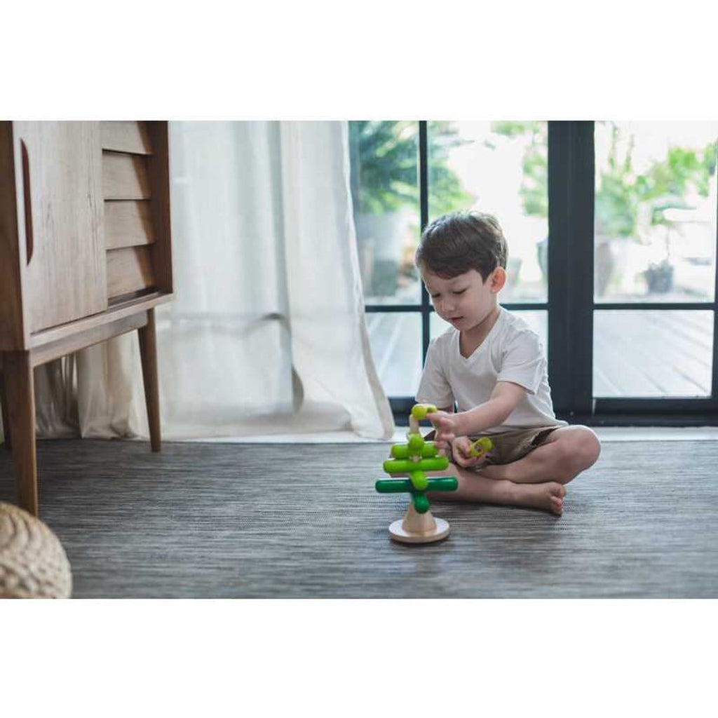 Kid playing PlanToys Stacking Tree