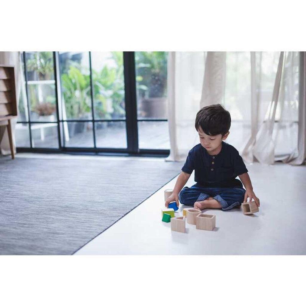 Kid playing PlanToys Geo Matching Blocks