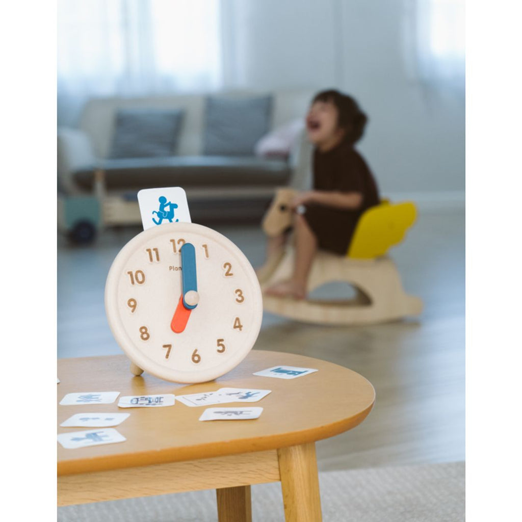 Kid playing PlanToys Activity Clock