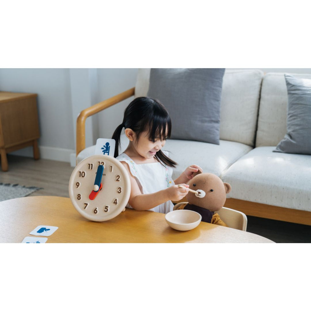 Kid playing PlanToys Activity Clock