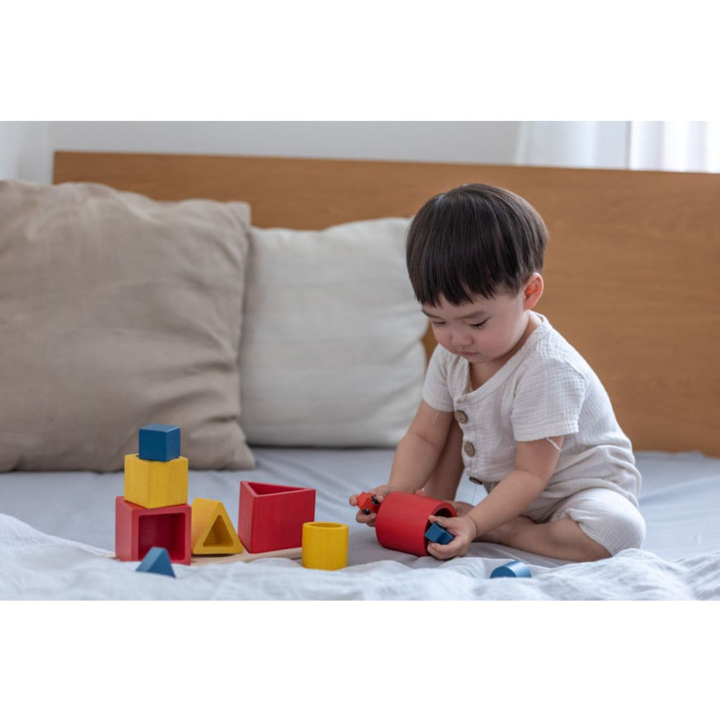 Kid playing PlanToys Nesting Puzzle - Unit Plus