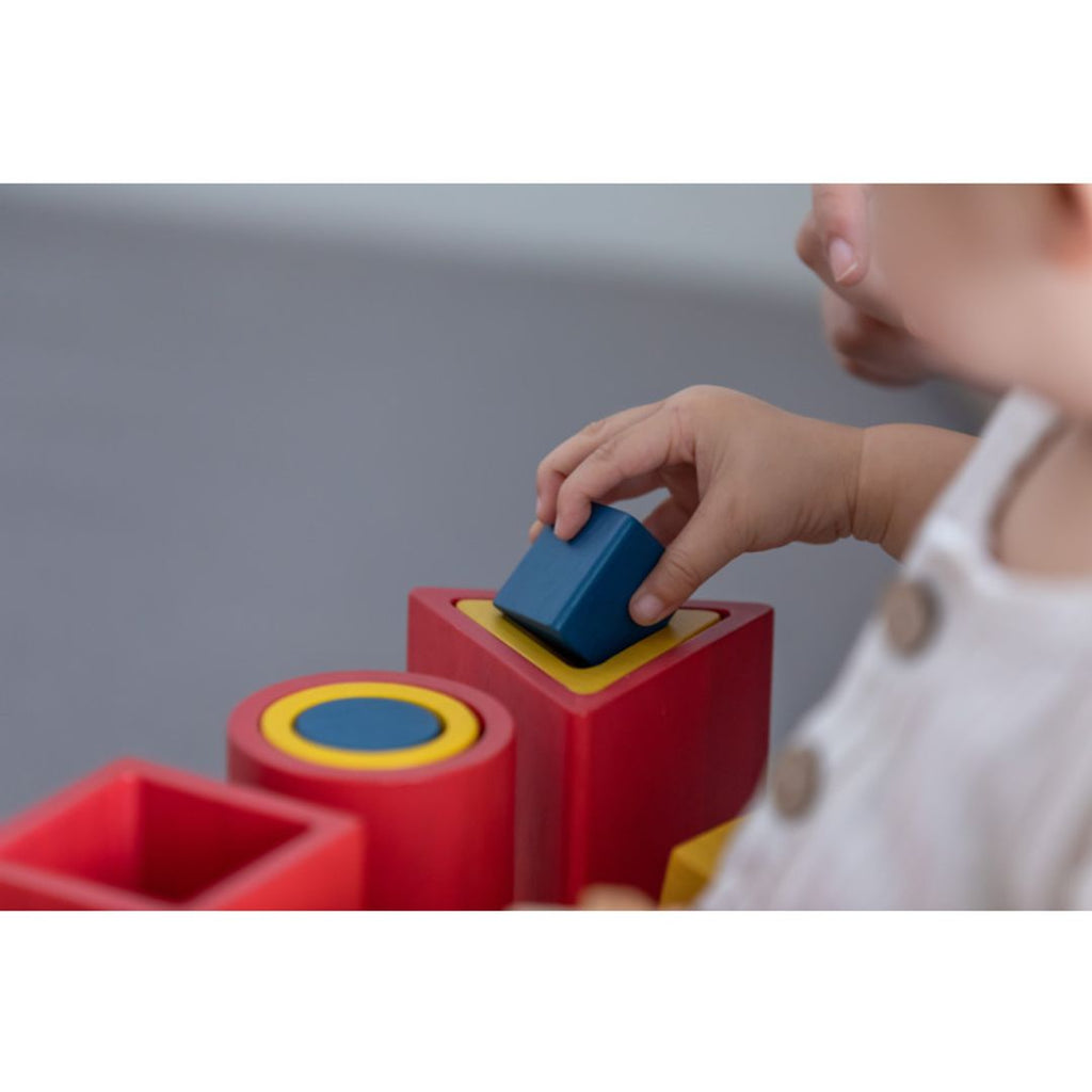 Kid playing PlanToys Nesting Puzzle - Unit Plus