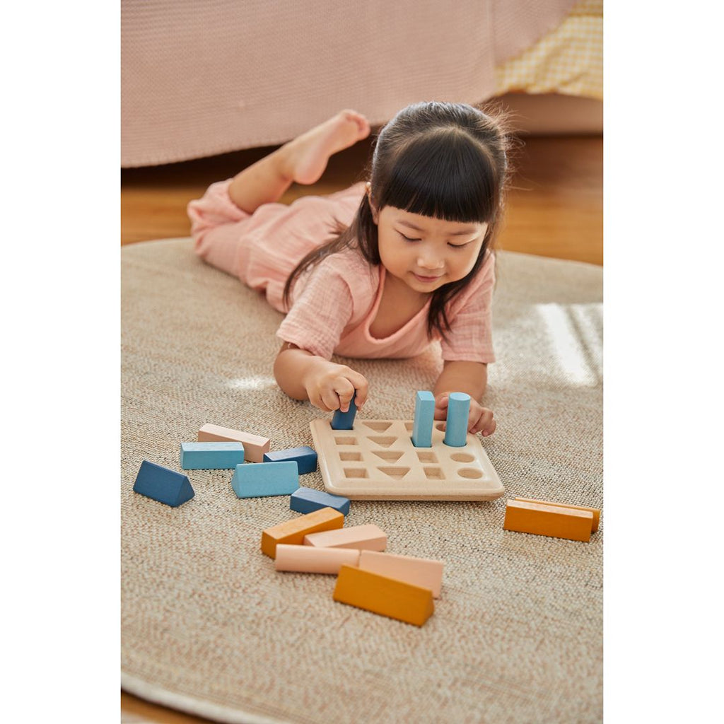 Kid playing PlanToys Geometric Peg Board - Orchard