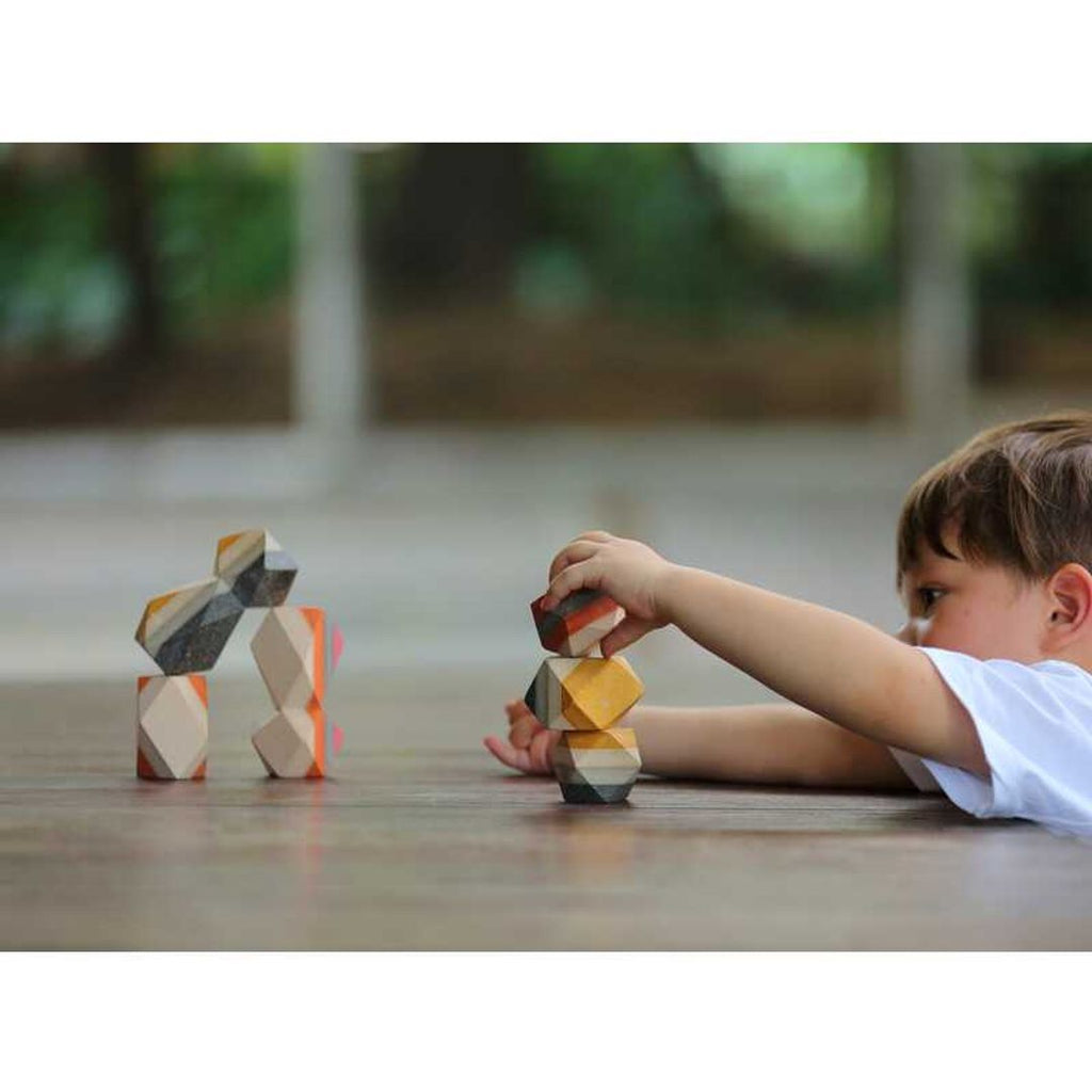 Kid playing PlanToys Geo Stacking Rock