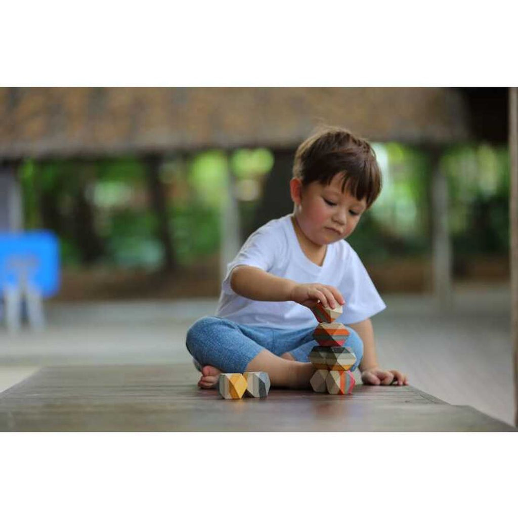 Kid playing PlanToys Geo Stacking Rock