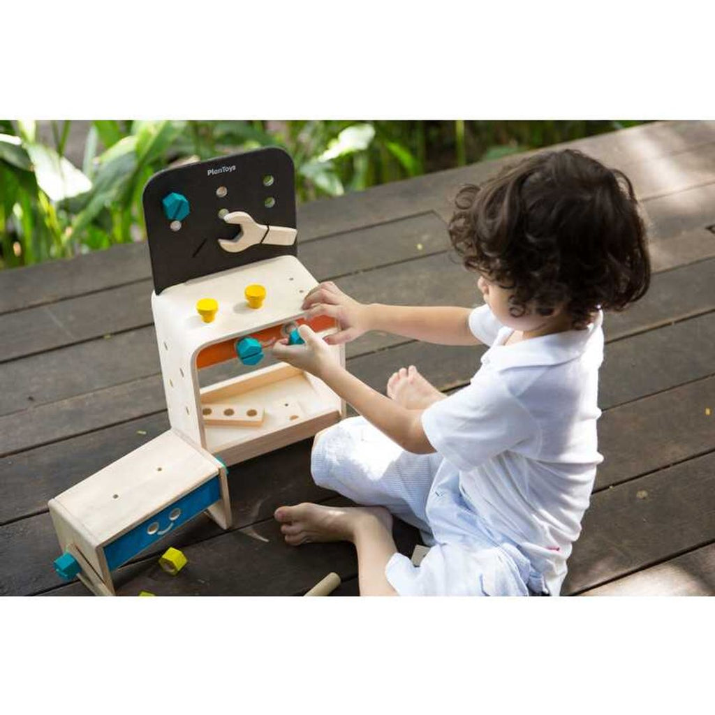 Kid playing PlanToys Workbench