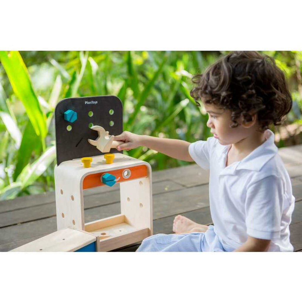 Kid playing PlanToys Workbench