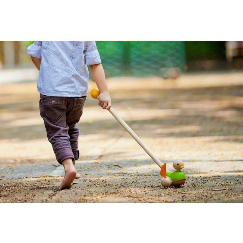 Kid playing PlanToys Push Along Duck