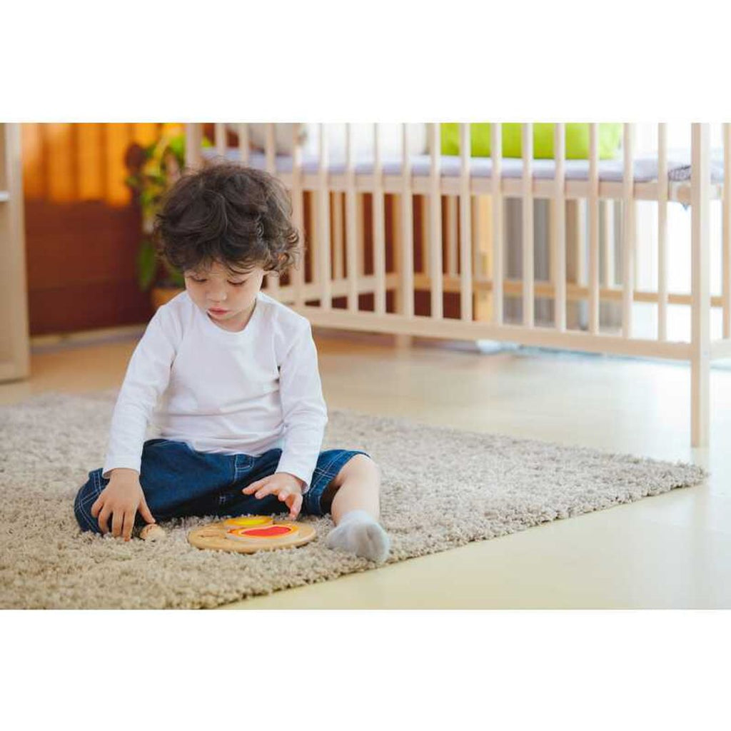 Kid playing PlanToys Chicken Puzzle